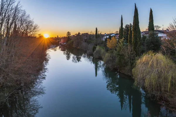 Cormons, İtalya 'da Komün, Friuli-Venezia Giulia, nehir kanalı ve ağaçlar, köyde günbatımı 