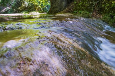Etrafı yeşilliklerle çevrili bir şelale. Acquacaduta. Friuli, İtalya