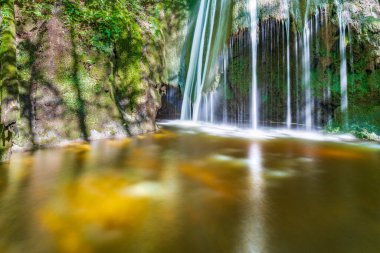 Etrafı yeşilliklerle çevrili bir şelale. Acquacaduta. Friuli, İtalya