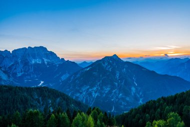Zirvede gün batımı. Lussari Dağı, gün batımına doğru son ışıklar. İtalya