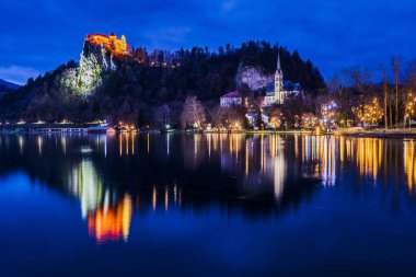 Bled Gölü 'nde bir gece. Noel atmosferi ve ışıklar. Bilgilendirme Kalesi ve Kilisesi