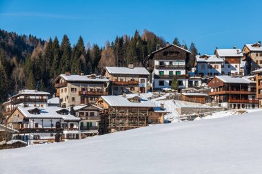 Karlı dağlarla ve köy kulübeleriyle güzel kış manzarası. İtalya 'nın Friuli-Venezia Giulia bölgesinde Udine ilindeki Sauris komünü manzarası. 