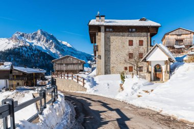 Karlı dağlarla ve köy kulübeleriyle güzel kış manzarası. İtalya 'nın Friuli-Venezia Giulia bölgesinde Udine ilindeki Sauris komünü manzarası. 