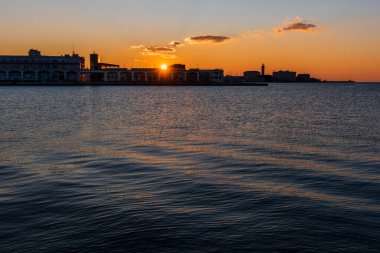 Trieste Audace rıhtımından gün batımı. Suyun üzerindeki ateş renkleri. İtalya