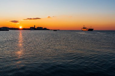 Trieste Audace rıhtımından gün batımı. Suyun üzerindeki ateş renkleri. İtalya