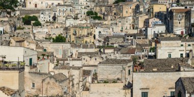 Matera 'lı Sassi. Sasso Barisano gün batımında. Mağara evlerinin büyüsü. UNESCO Dünya Mirası Alanı.