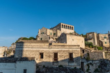 Matera 'lı Sassi. Sasso Barisano gün batımında. Mağara evlerinin büyüsü. UNESCO Dünya Mirası Alanı.