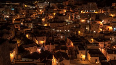 Matera, İtalya 'daki antik şehir sokaklarının ve evlerin gece manzarası