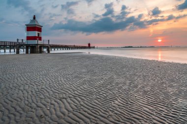 Gün doğumunda İtalya tatil Lignano deniz feneri ile Plaj