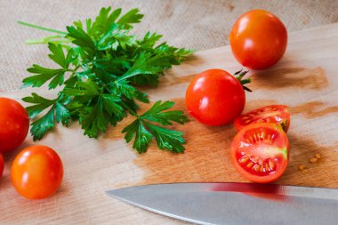 Tahta arka planda taze domates ve maydanoz.