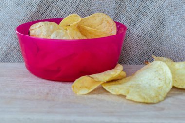 Tahta arka planda patates cipsi