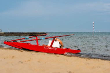 Sahildeki kırmızı tekne doğal arka planda.