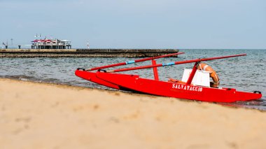 Sahildeki kırmızı tekne doğal arka planda.