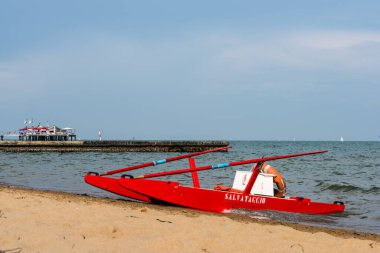 Sahildeki kırmızı tekne doğal arka planda.