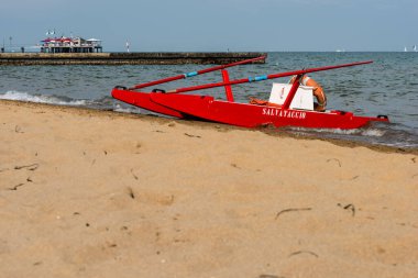 Sahildeki kırmızı tekne doğal arka planda.