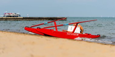 Sahildeki kırmızı tekne doğal arka planda.