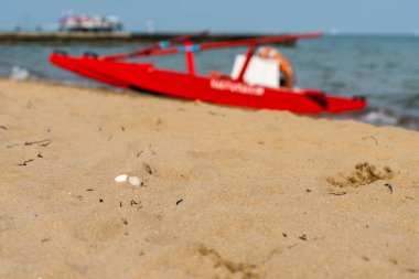 Sahildeki kırmızı tekne doğal arka planda.