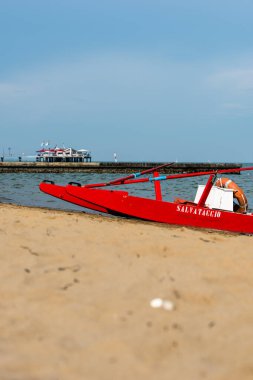 Sahildeki kırmızı tekne doğal arka planda.