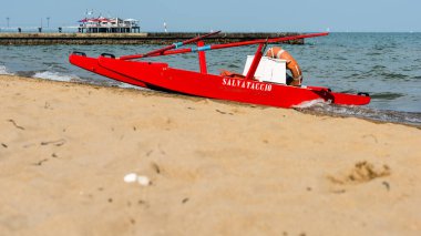 Sahildeki kırmızı tekne doğal arka planda.
