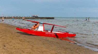 Sahildeki kırmızı tekne doğal arka planda.