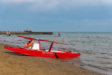 Sahildeki kırmızı tekne doğal arka planda.