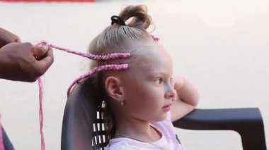 Şehrin sokaklarında örülmüş örgü örgüleri. Afrika örgüleri örme süreci.