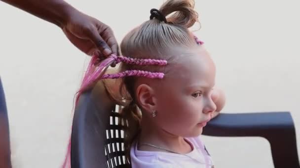 Afro-pigtails op straat van de stad.Het proces van het vlechten van Afrikaanse vlechten — Stockvideo