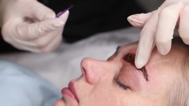 Мастер делает постоянный макияж бровей специальным пигментом — стоковое видео