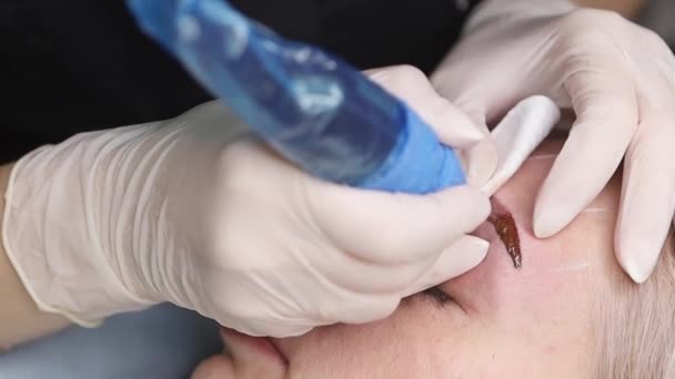 Der Meister macht Permanent-Augenbrauen-Make-up mit einer Nadel-Tätowiermaschine — Stockvideo