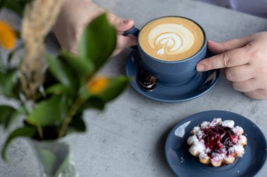 Cappuccino 'da güzel bir süt köpüğü deseni. Tabakta çilekli tatlı..