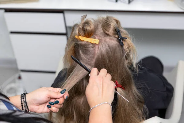 The hair is pulled up and pinned with clips.A girl in a barber chair — Stock Photo, Image