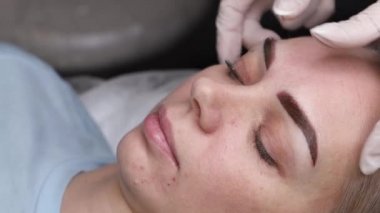 Usta kaşlardaki yeni uygulanan pigmentleri kontrol eder.