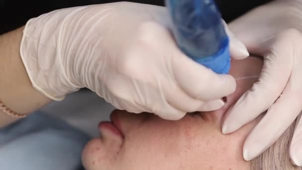 El maestro hace maquillaje permanente de la ceja con una máquina del tatuaje de la aguja — Vídeos de Stock