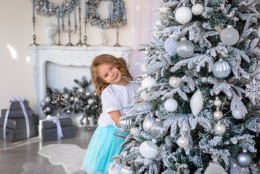 Güzel bir Noel ağacının arkasından bakan bir kız 