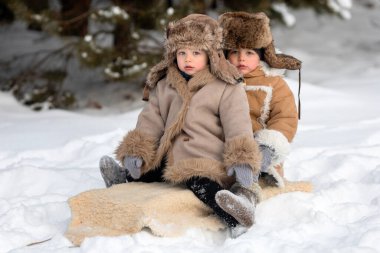 Two cute kids in winter Russian folk clothes like in a fairy tale