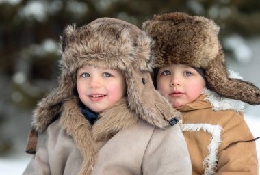 Two cute kids in winter Russian folk clothes like in a fairy tale