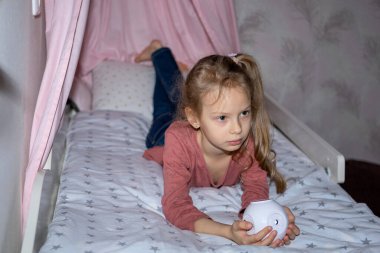 Kızın elinde film izlemek için küçük bir projektör var.