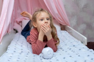 Kızın elinde film izlemek için küçük bir projektör var.