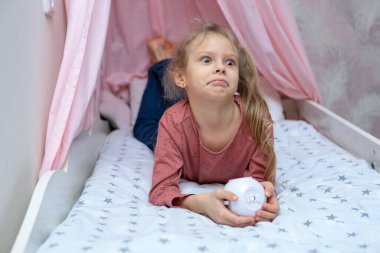 Kızın elinde film izlemek için küçük bir projektör var.