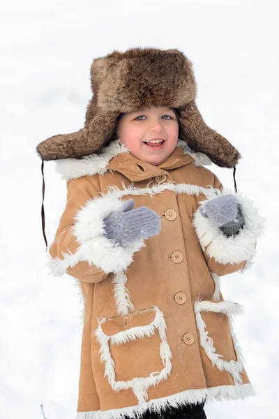 Dzieciak w zimowym futrze, kapeluszu i butach filcowych w śnieżnym lesie — Zdjęcie stockowe
