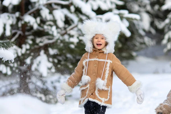 Una ragazza in un buffo cappello di pelliccia con bambù in una foresta innevata — Foto Stock