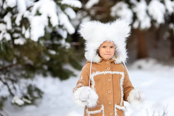 Una ragazza in un buffo cappello di pelliccia con bambù in una foresta innevata — Foto Stock