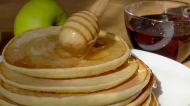 アメリカのパンケーキが蜂蜜を注ぐ 蜂蜜用の木製スプーン 伝統的なおいしい甘い朝食 — ストック動画