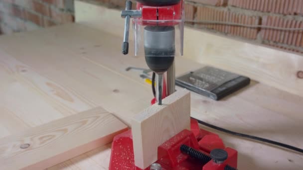 Werkman boor gat in houten plaat met werktuigmachine. Zingende, langzame beweging. — Stockvideo