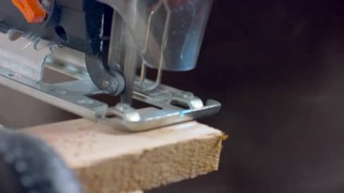 Marangoz elektrikli yapbozda çalışıyor, yakın plan, detay. Talaş sineği.