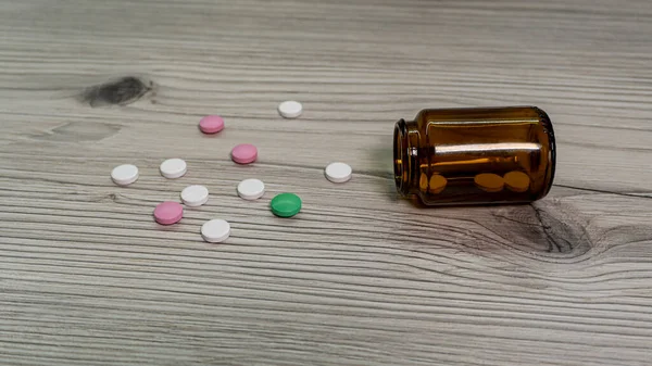 Les Pilules Colorées Sont Dispersées Sur Table Côté Bouteille Médicament Photo De Stock