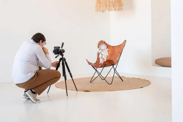 最小的照明和通风室内设计 男摄影师 在最小的轻便和通风的内部 白色和米黄色椅子 地毯和枕头工作 — 图库照片