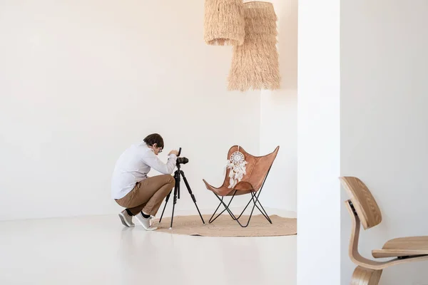 最小的照明和通风室内设计 男摄影师 在最小的轻便和通风的内部 白色和米黄色椅子 地毯和枕头工作 — 图库照片