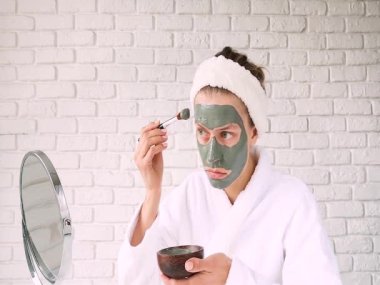 Güzel bir kadın cildine iyi bakar. Yeşil bir sağlık maskesi takar.