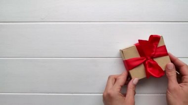 Sevgililer Günü geçmişi. Kadın elleri beyaz arka plana sevgililer günü hediyesi koyuyor
